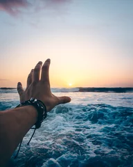 Die Hand einer Person streckt sich der Sonne entgegen © Eimantas