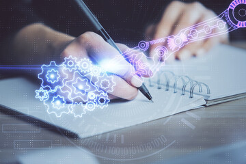 Double exposure of writing hands on background with data solution hologram on front. Technology...