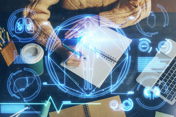 Education theme hologram over woman's hands writing background. Concept of study. Double exposure