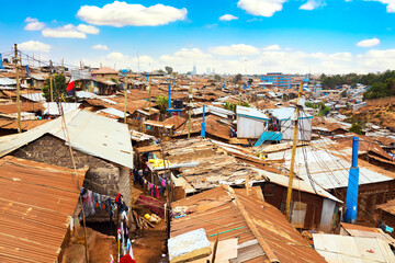 Kibera slum in Nairobi during sunny day with blue sky and clouds. Kibera is the biggest slum in...
