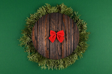 Top view of Christmas greeting card from evergreen branches, wooden standand red baw. Minimalism concept