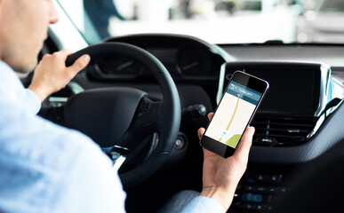 Driver Using Smartphone With Car Navigation App Driving In City
