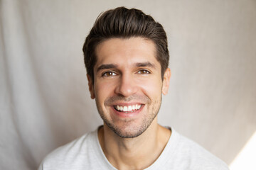 Portrait of a young handsome guy with a beautiful smile with healthy hair, skin and teeth