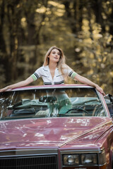 stylish woman looking away while standing in vintage cabriolet