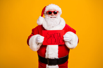 Fototapeta na wymiar Portrait of his he nice attractive cheerful cheery confident bad Santa holding in hands red board wanted search seeking occupation isolated bright vivid shine vibrant yellow color background
