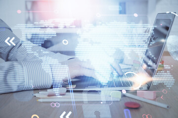 Multi exposure of world map hologram with man working on computer on background. Concept of...