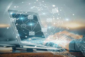 Envelop hologram drawing with businessman working on computer on background. Electronic mail concept. Double exposure.