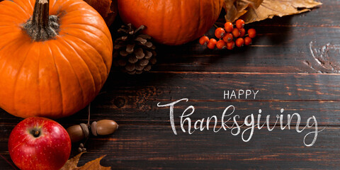 Thanksgiving greetings. Dry yellow leaves, pumpkins, berries, nuts and frame on a wooden...