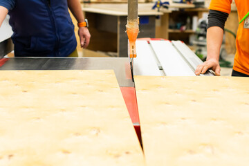 Professional circular saw on a board in a carpentry workshop. A circular saw cutting plywood.