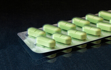 Medical pills in packing on black background