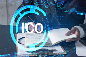 ICO symbol hologram and a woman taking notes. Business blockchain start-up concept. Multiexposure.