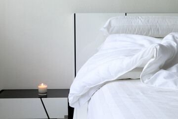 white blanket towel and pillows are on the white bed in the nice white bedroom of the hotel resort...