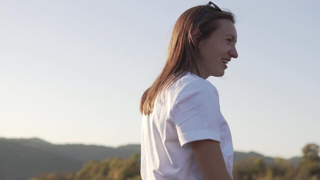 A beautiful female tourist walks in the mountains in Sochi at sunset.