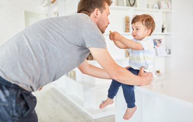 Fototapeta premium Kleinkind als Sohn gibt seinem Vater einen Keks