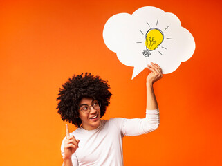 Creative ideas and innovations. African American guy holding speech bubble with light bulb over his...