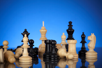 Black and white chess pieces standing together on blue gradient background. Team work concept.