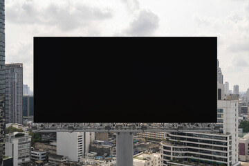 Obraz premium Blank black road billboard with Bangkok cityscape background at day time. Street advertising poster, mock up, 3D rendering. Front view. The concept of marketing communication to promote or sell idea.