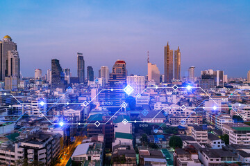 Glowing hologram of technological process, aerial panoramic cityscape of Bangkok at sunset. The largest innovative hub of tech services in Asia. Multi exposure.