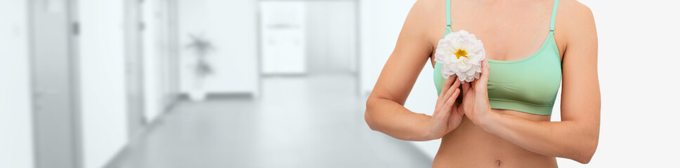 Female breast with flower, over corridor hospital background. Concept prevention of breast...