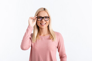 Front view of happy blonde woman in pink long sleeve holding eyeglasses frame, while looking at...
