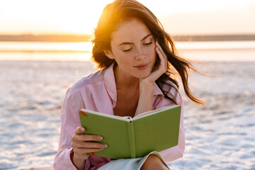 Smiling beautiful young woman reading a book