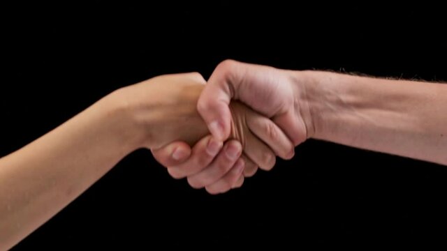 Close up studio shot of man's hand and woman's hand shaking hands