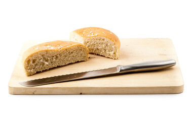 Fresh sliced focaccia and knife on wooden cutting board, isolated on white background.