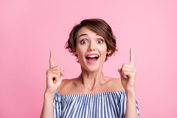 Obraz premium Photo portrait of woman pointing two fingers up with open mouth isolated on pastel pink colored background