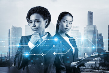 Two young astonishing businesswoman pondering about technology as a business necessity for tremendous growth in commerce. Tech hologram icons over Singapore background.