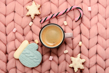 Cup of coffee with marshmallows, staff, Gingerbread Cookies on pink knitted merino plaid top view. Christmas card, concept, mood.