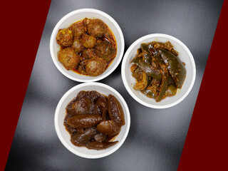 Group photograph of indian pickles or achar like amla pickle, mango pickle and lemon pickle, sarved in white ceramic bowl, Top angle shot