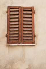old window with wodden shutters, wall weathered and cracked, space for text and vertical format