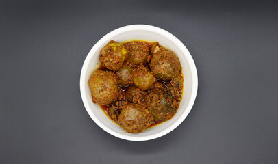 Homemade Gooseberry or amla Pickle or Aavle ka Achar in a bowl or barni on white background. top angle shot