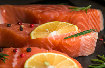 fresh trout fillet, Close up raw and fresh salmon. Fresh raw fish fillet with cooking ingredients, herbs and lemon on black background