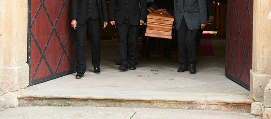 Group of survivors carries a coffin out of the church after a funeral mass