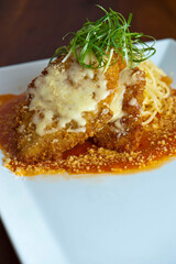 Chicken parmigiana Traditional Italian comfort dish. Chicken breast covered in breadcrumbs lightly fried, topped with homemade marinara, melted mozzarella, parmigiana provolone and Italian parsley. 