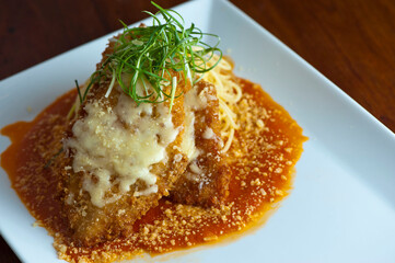 Chicken parmigiana Traditional Italian comfort dish. Chicken breast covered in breadcrumbs lightly fried, topped with homemade marinara, melted mozzarella, parmigiana provolone and Italian parsley. 