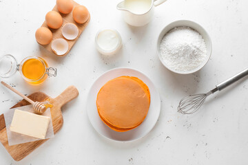 Tasty pumpkin pancakes with ingredients on table