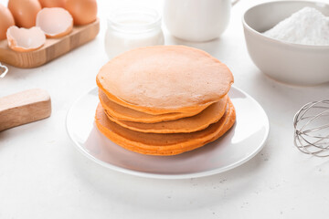Fototapeta na wymiar Tasty pumpkin pancakes with ingredients on table