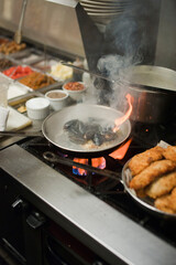 Steamed mussels. Mussels being prepared by a chef in a restaurant kitchen. Classic Italian restaurant entree favorite. Shellfish and seafood prepared with pork, sauces, meats and cheeses.
