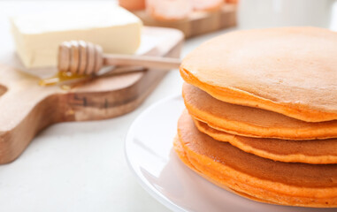 Tasty pumpkin pancakes on table, closeup