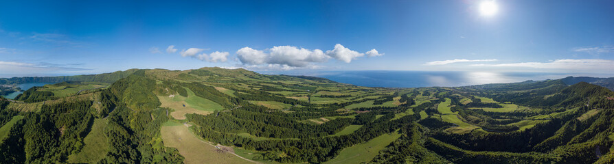 Panoramic view over the green landscape and the Atlantic ocean, in the zona of Sete Cidades, São Miguel island in the Azores. - obrazy, fototapety, plakaty