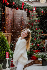 Teen girl posing at the back yard against Christmas background. Snowing.