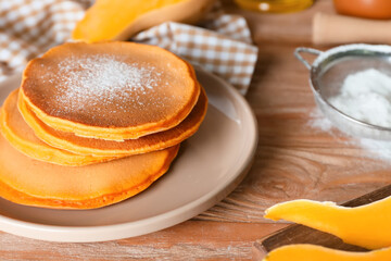 Tasty pumpkin pancakes on table