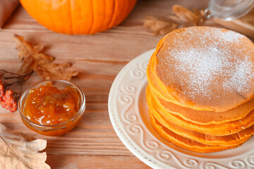 Tasty pumpkin pancakes on table