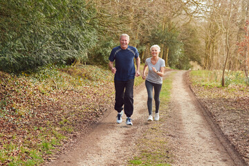 Fototapeta premium Senior Couple Exercising In Autumn Countryside During Covid 19 Lockdown