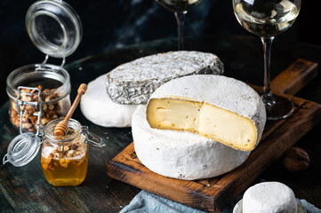 Various types of cheese composition. Gorgonzola, camembert, brie cheese. Roquefort, dor blue. Walnut and wine. Appetizer and gourmet food. Honey in jar