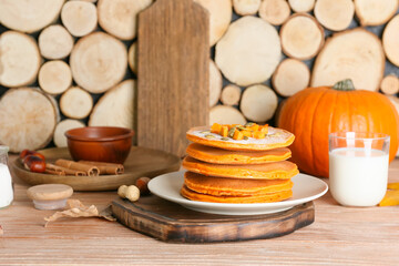 Tasty pumpkin pancakes on table