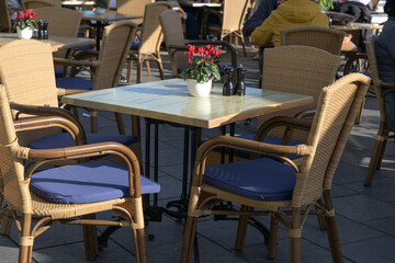 Empty table in a street cafe at a sunny day after the strict lockdown during the coronavirus...