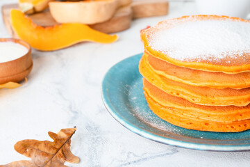 Tasty pumpkin pancakes on table